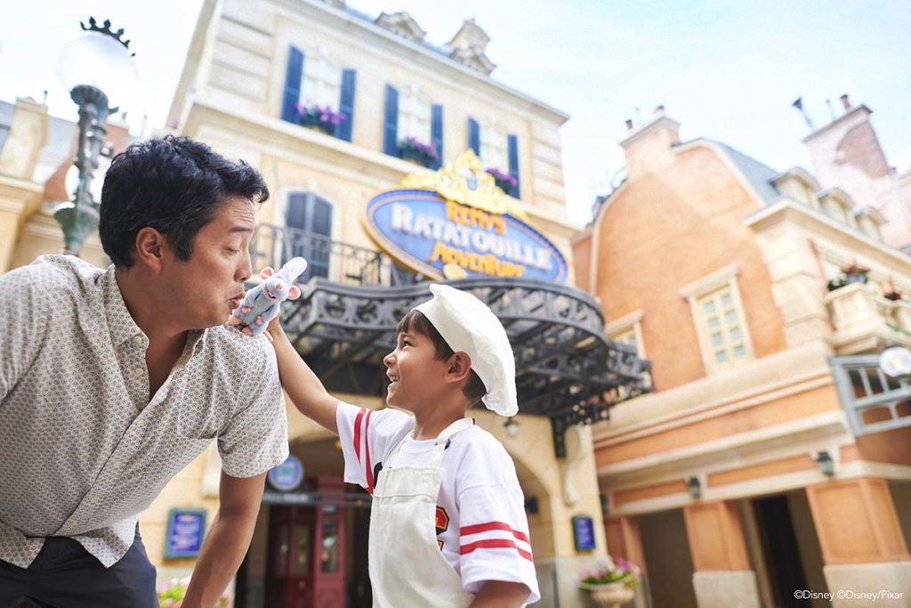 Dad and son in chef's hat outside the Remy's Ratatouille Adventure attraction at Walt Disney World. Photo c. Walt Disney World Resort