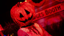 Pumpkin headed man with dark stage background, from Universal Studios Florida.