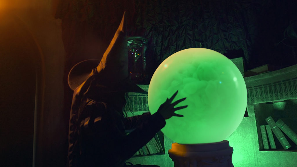 Scary creature is looking at a green crystal ball at 13th Gate, a haunted house in Baton Rouge, Louisiana.