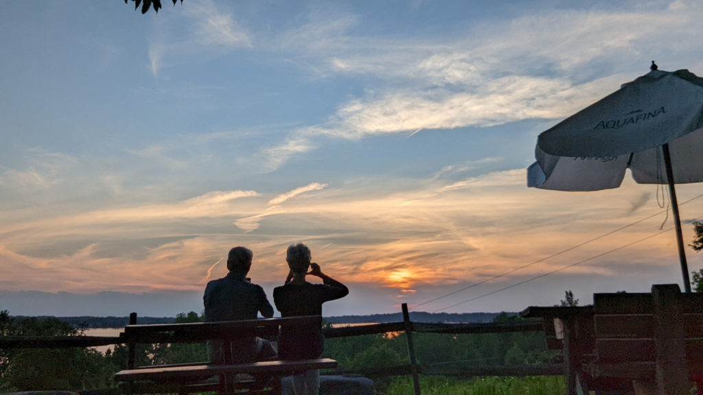 Couple taking photos of the sunset over Lake Owasco, Finger Lakes, New York