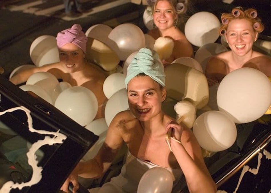 Four people in bath towels dress like women in a bubble bath during the famous Village Halloween Parade in New York City.
