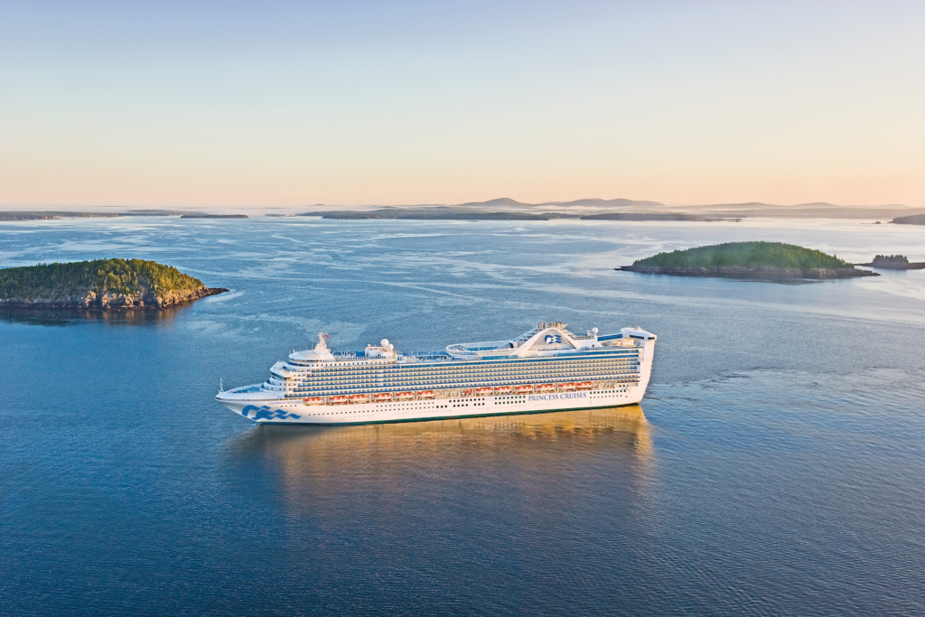 Princess Cruises ship at sea off the coast of Maine with rocky islands in the background.