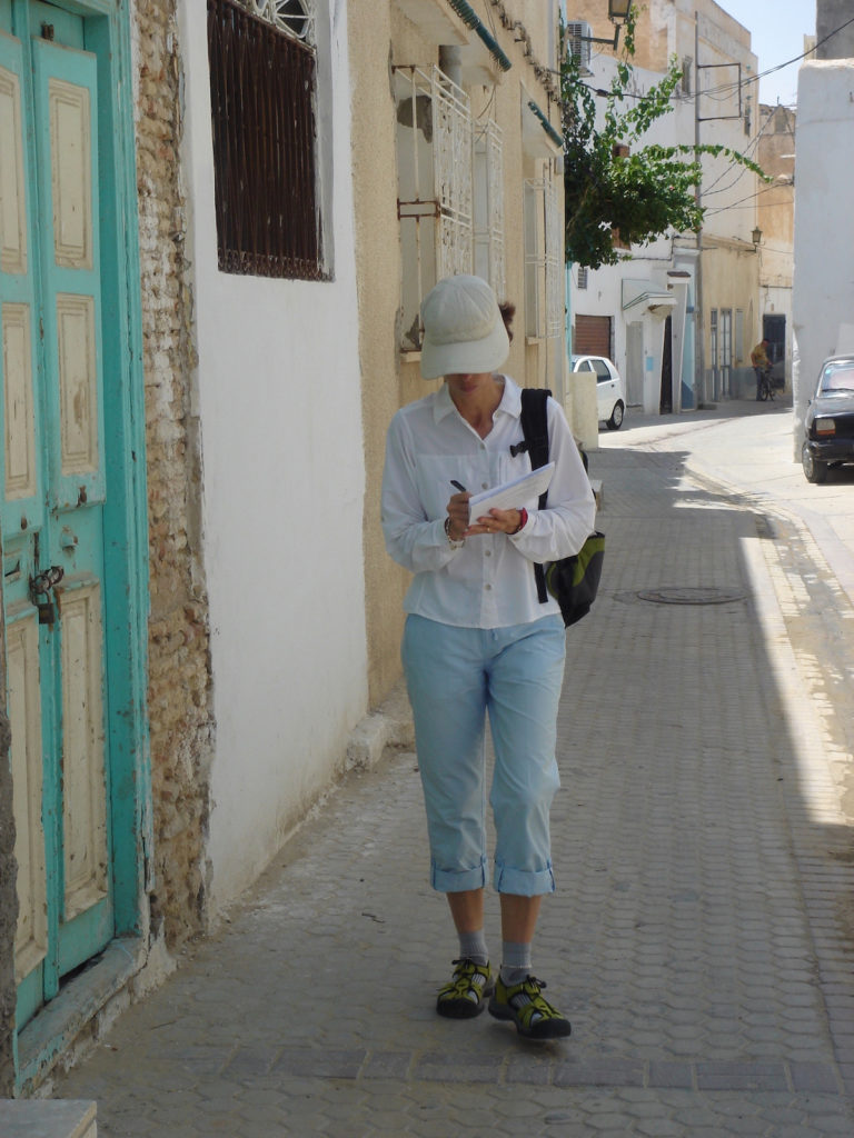 Woman taking notes while walking on a Morocco sidewalk