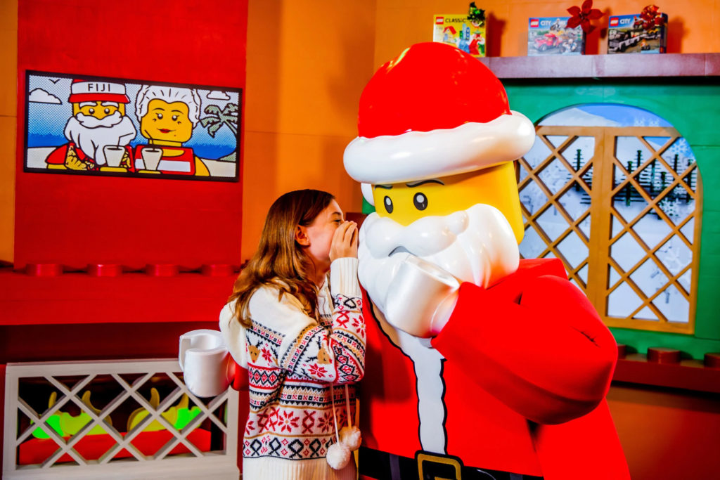 Girl talking to a LEGO Santa Claus during the holidays in Orlando.