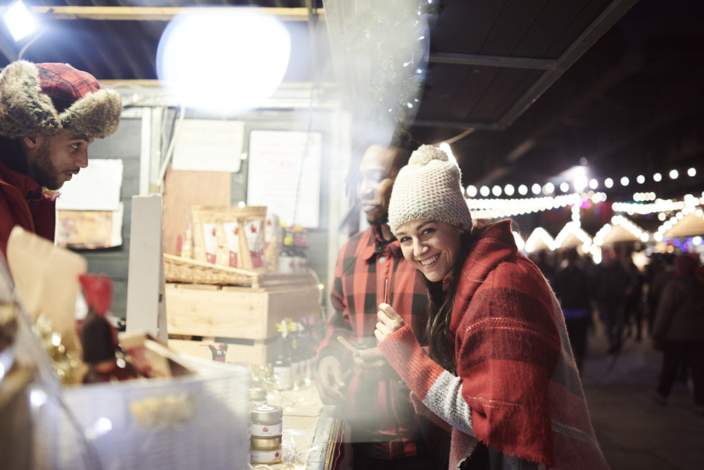 Couple at a food stall at the London Christmas Market, Southbank. Photo c. VisitBritain/Rama Knight