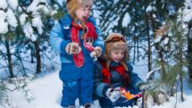Kids in snowsuits scream while playing in the snow.