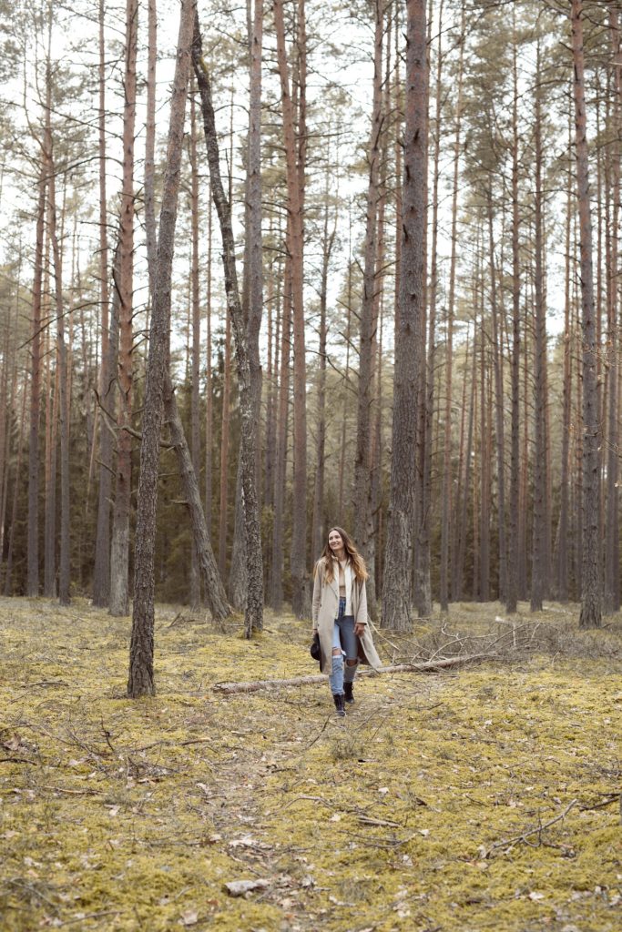 Woman walks though the woods.