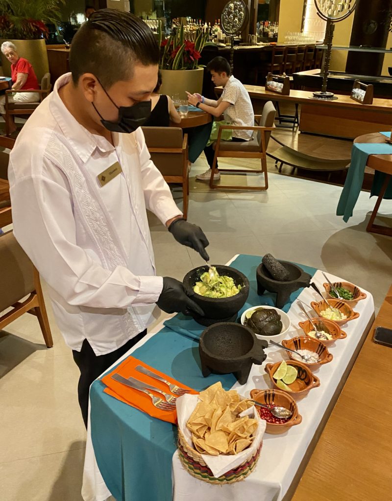 Man prepares an authentic guacamole tableside at Grand Residences Cancun dining room.