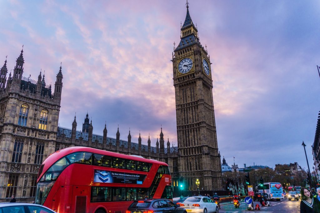 New London Transport bus drives down boulevard in front of Big Ben.