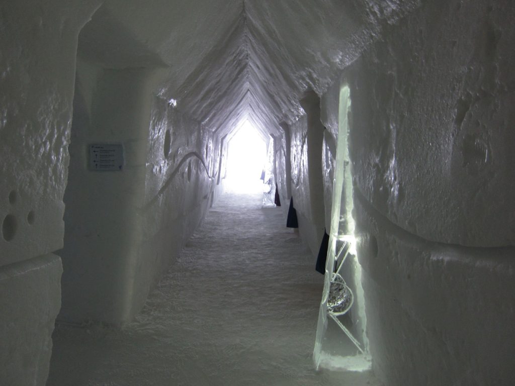Ice Hotel corridors are carved and illuminated by candles in ice holders.