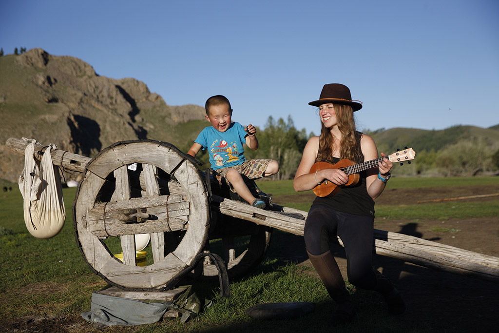 Toddler and guest enjoy some music after a day on horseback with Wild Earth Journeys Mongolia tour. Photo by Thomas L. Kelly