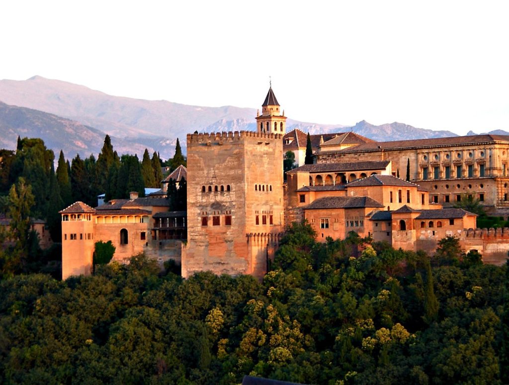 The Alhambra, a UNESCO World Heritage site and gem of Andalusian and Moorish styles, towers over the Granada skyline. Photo c. pixabay.