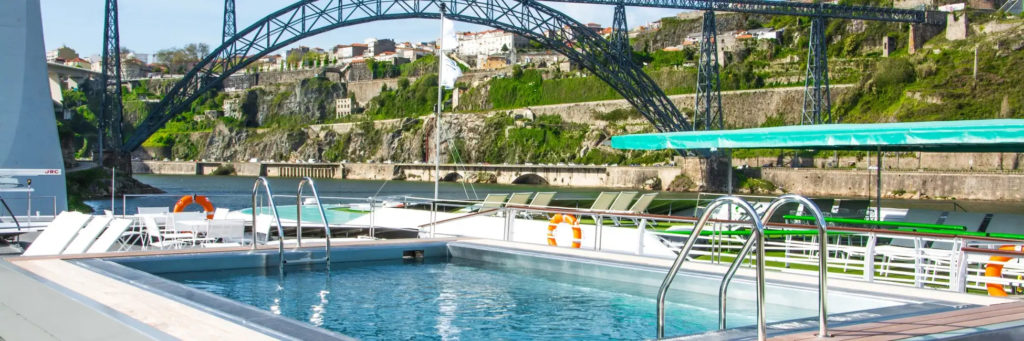 The upper deck swimming pool on the MS Miguel Torga river cruiser is a favorite place for families to relax when doing a Douro River cruise. Photo c. Stephane Pfleger for Croisieurope