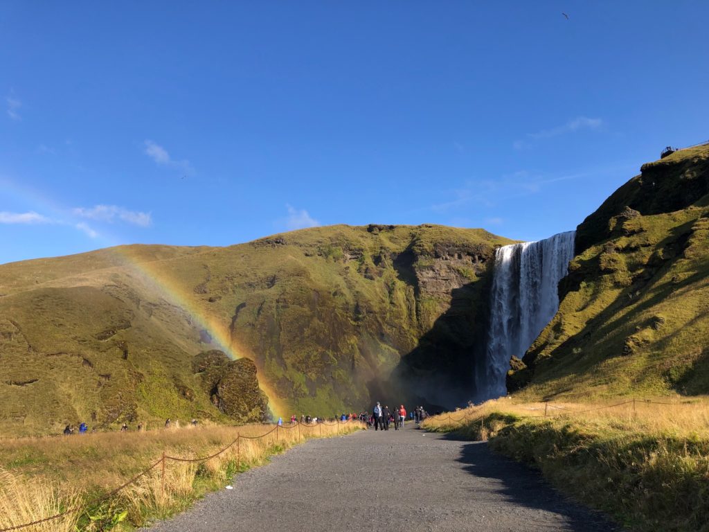 There's such bright sunlight that mist from Iceland's Skogafoss waterfall frequently inspires rainbows. Photo by Bethany Kandel