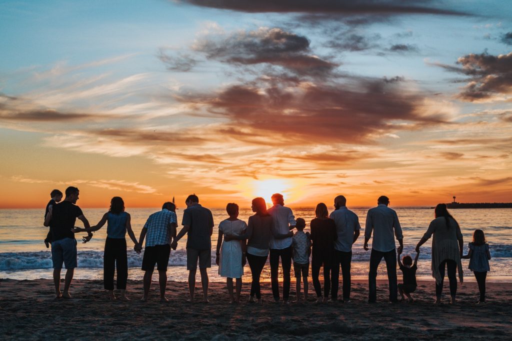 Family reunion group watches sunset along the beach Photo by tyler Nix for unsplash