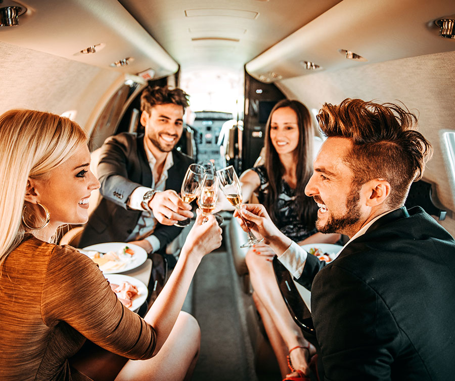 Jetlevel Aviation inside of private jet cabin where two couples toast each other with champage.