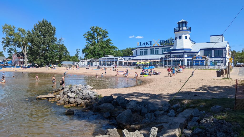 Gold sand beach cove and a large white restaurant, the Lake House, on the shores of Oneida Lake at Sylvan Beach, New York.