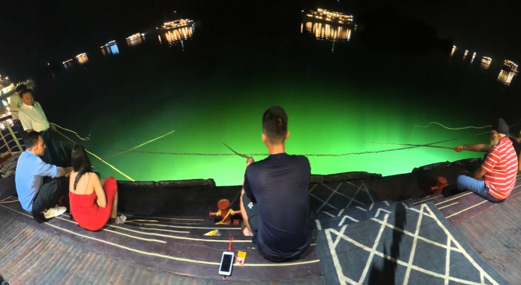 Five cruise passengers try squid fishing off the back deck of the Ambassador Halong Bay cruise ship in Viet Nam.