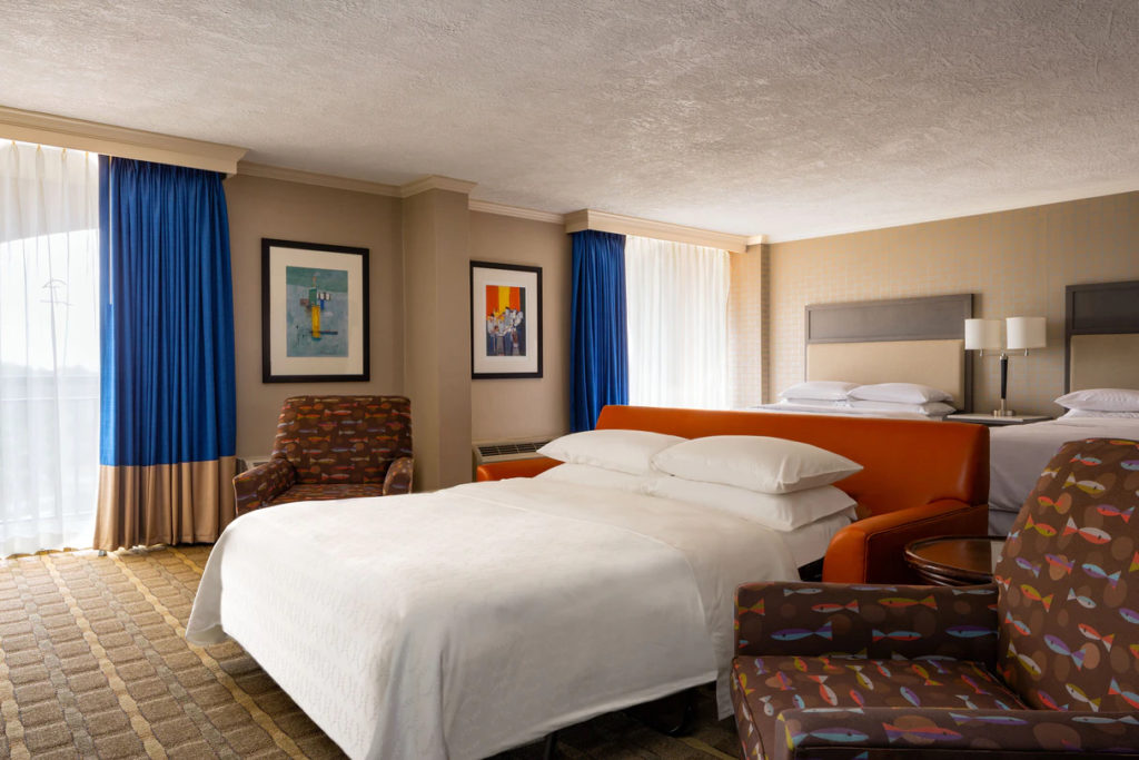 Family suite with made up queen sofabed and two queen beds at the Sheraton Sand Key Resort in Clearwater Beach.