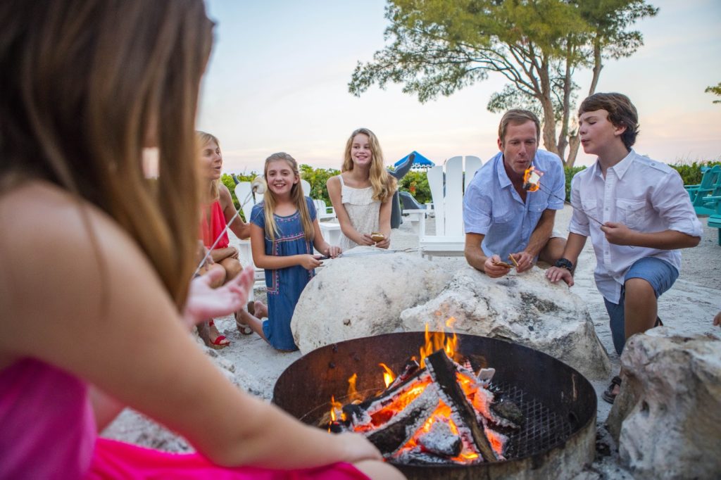 Family group enjoying the outdoor firepit and s'mores at the RumFish Beach Resort in St. Pete Beach, Florida. Photo c. Tradewinds Resorts