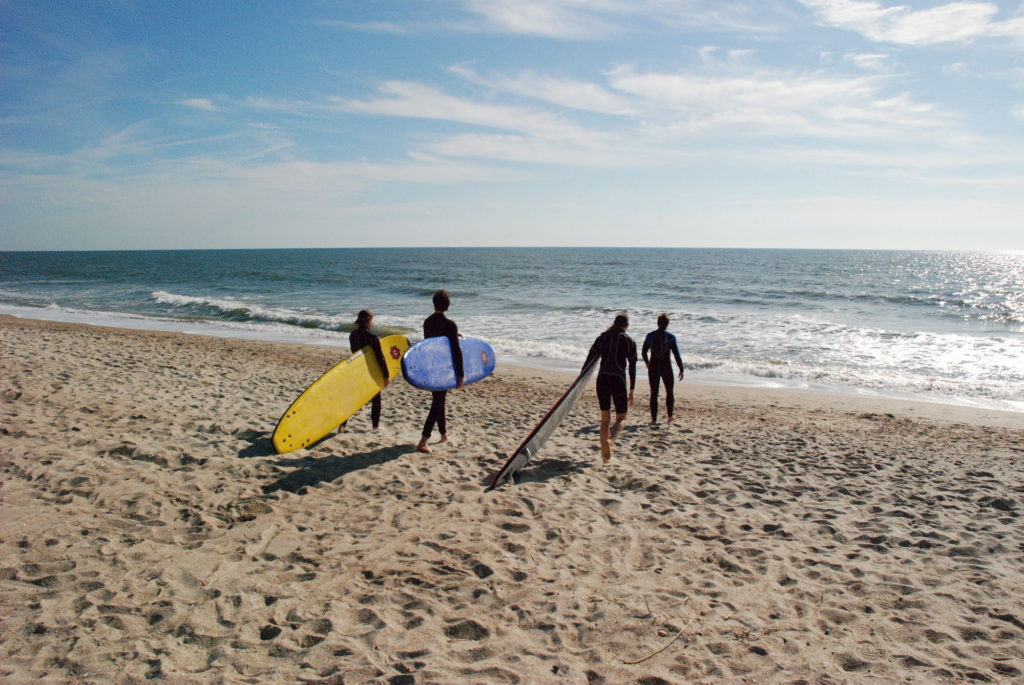 Surfers carry their boards across the sand to the Atlantic coast at the Amelia Island beach.
