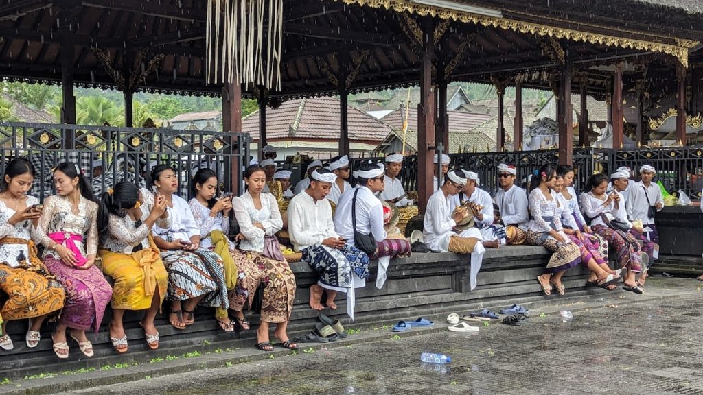 Worshippers wait in the rain to receive a blessing from the priest at Puri Besakih, the mother temple of the island.