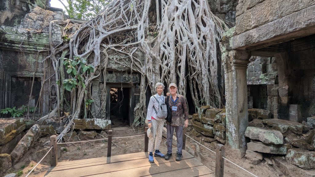 Homem e mulher posam em Wat Phra Thom em frente a um templo onde "Tomb Raider" foi filmado.
