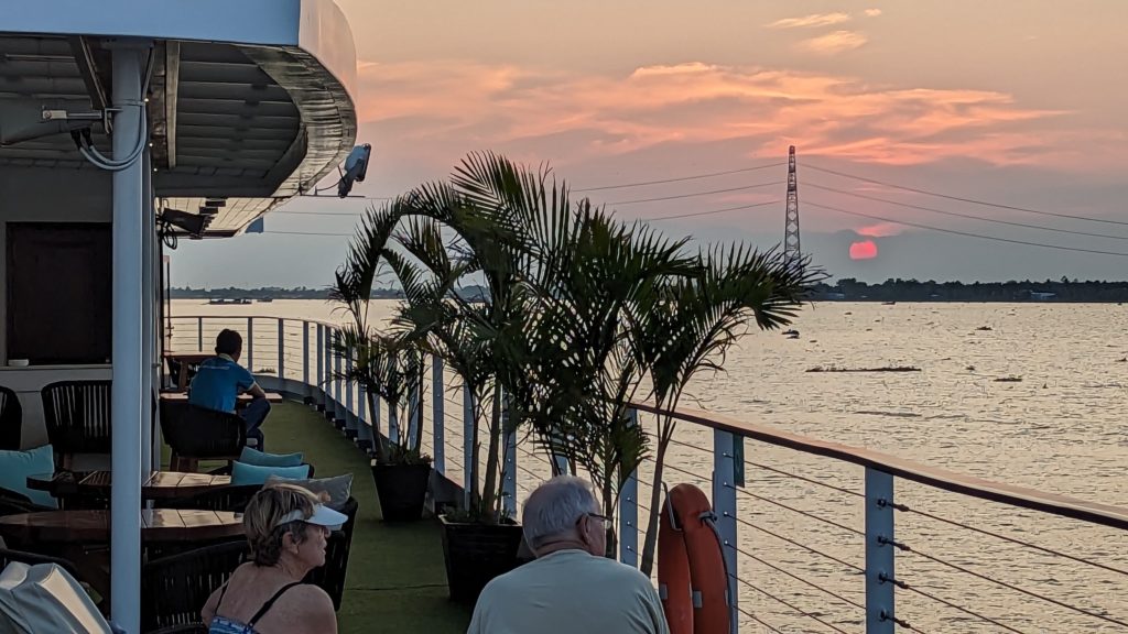 Passengers relaxing on the upper deck of Indochine II, a river boat from CroisiEurope sailing the Mekong River.