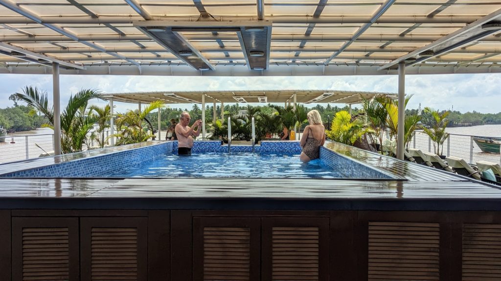 Homem tira foto de uma mulher na piscina da cobertura do Indochine II, um cruzador fluvial da CroisiEurope no rio Mekong.