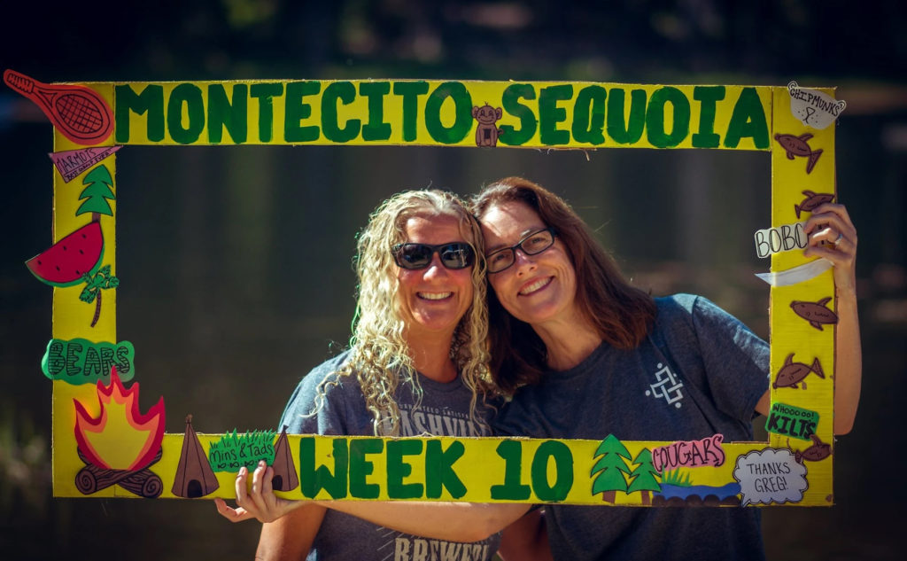 Two women pose for a picture in a fun frame from the Montecito Sequoia family camp. Photo c. Montecito-Sequoia Lodge