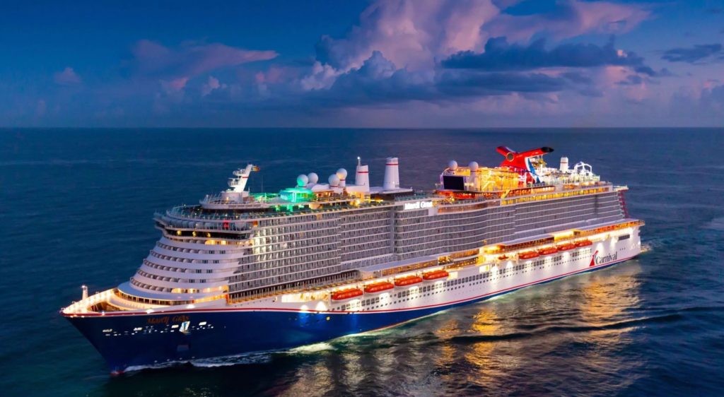 The Carnival Mardi Gras ship is illuminated on each deck while sailing at night. Photo c. Carnival
