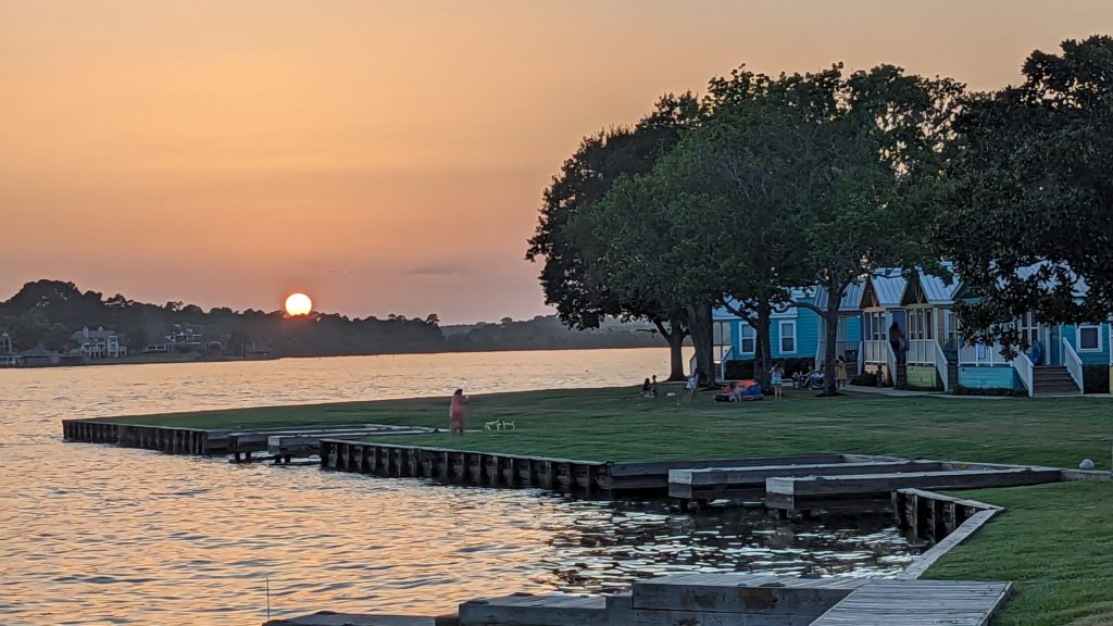 View of lakefront cottages at Margaritaville Lake Resort on Lake Conroe as the sun sets.