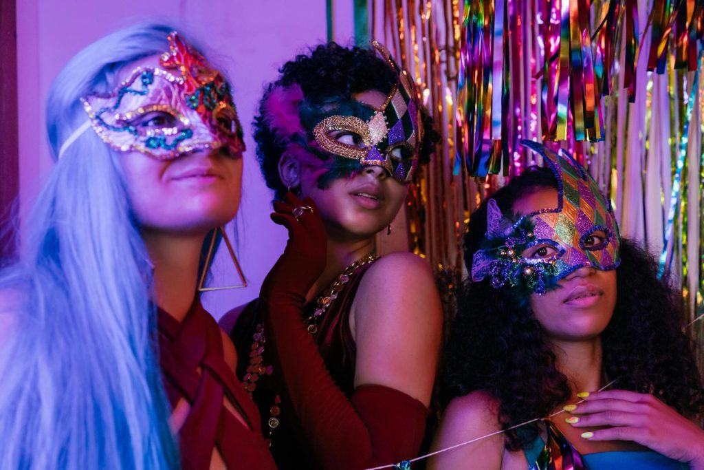 Three women in Carnival masks are ready for a party.