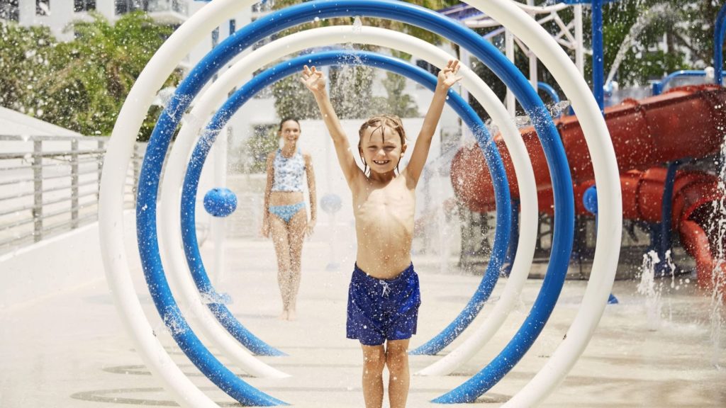 Boy playing with a hoop in a waterpark at The Diplomat Resort, Hollywood, Florida.