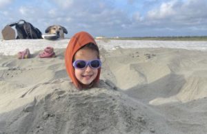 thumbnail of Girl buried in the sand at the beach