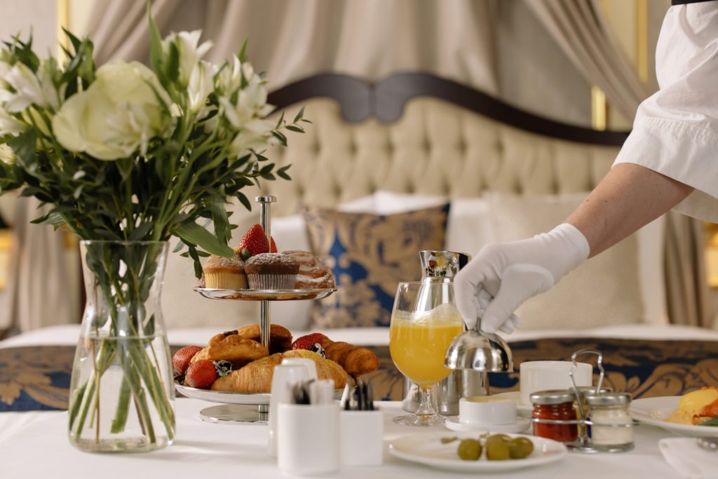 Room service cart is elegantly set for breakfast in fancy hotel.
