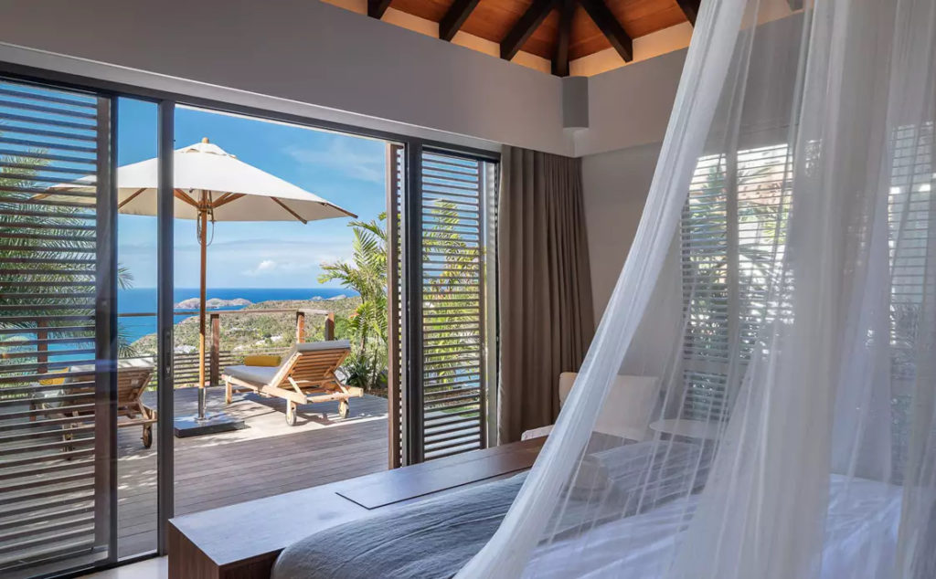 A villa bedroom overlooking the sea on the island of St Barts, part of the LeCollectionist villa rental collection.