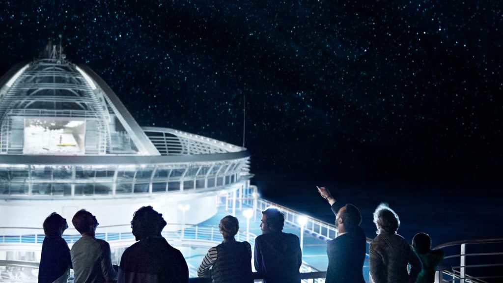 Passengers on cruise ship in silhouette look up at the stars on a Princess Cruise.