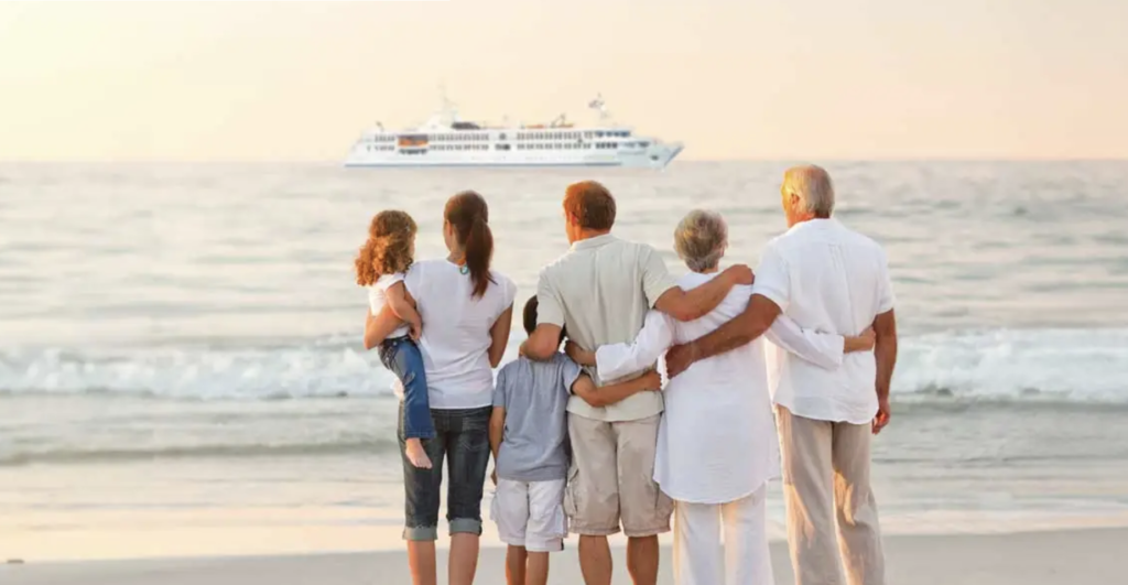 Three generations stand on the Mediterranean shoreline and admire their CroisiEurope ship moored offshore. Photo c. CroisiEurope