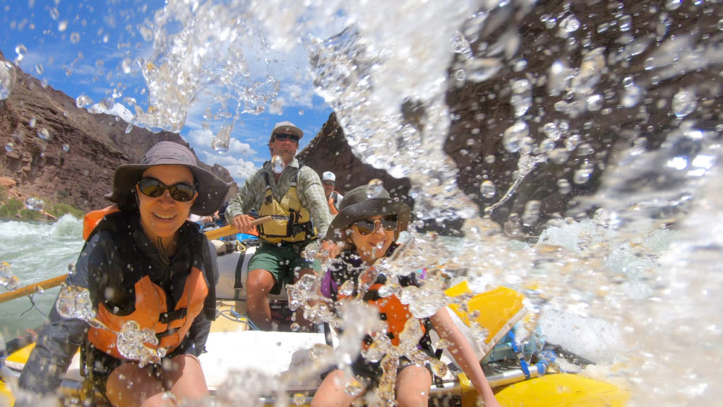 Family on an inflatable raft ride the rapids down the Grand Canyon with OARS outfitters. Photo by Josh Miller for OARS