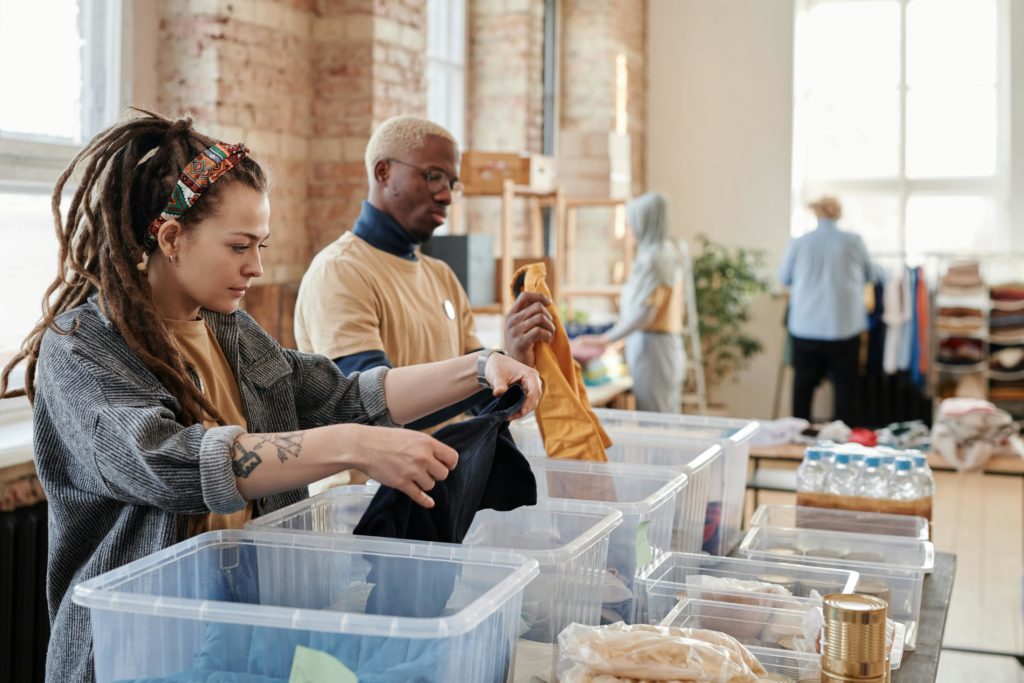 Volunteers sort clothes at a clothes bank near to home to help others. Photo by Julia Cameron for pexels.