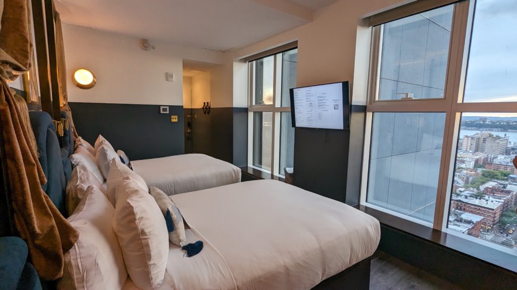 Two double beds at New York's Civilian Hotel focus on the city skyline view west over Hell's Kitchen to the Hudson River. Photo c. Ron Bozman/Spring Hill Prods
