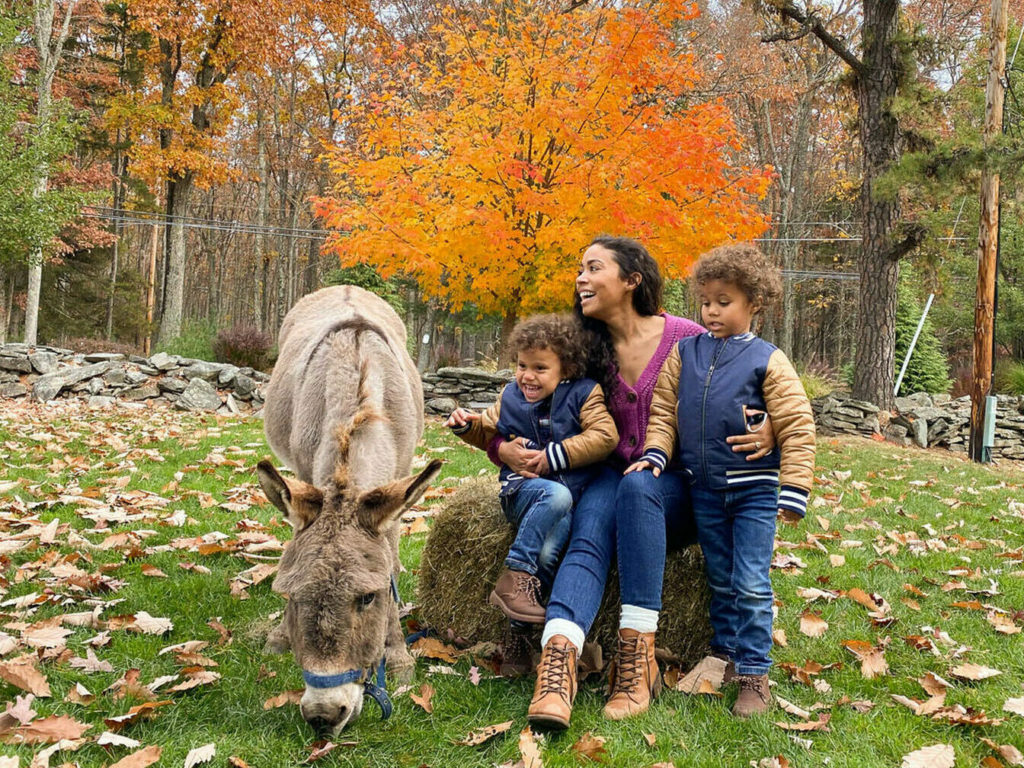 Mom and two boys pet a donkey at the Woodloch Pines resort in the Pocono Mountains. Photo c. Woodloch.com