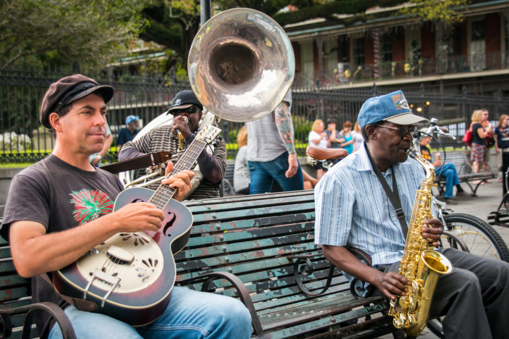 An improvised street trio of guitar, bass horn and sax playing New Orleans jazz on Jackson Square. Photo by Rebecca Todd/NewOrleans.com