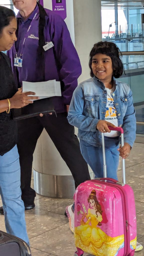 Guia do Aeroporto de Heathrow ajuda mãe e filho com mala Disney Princess a trocar de avião.