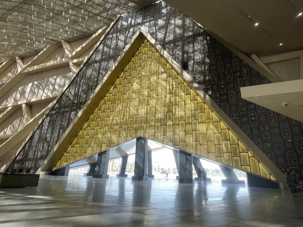 The main doors at the open Grand Egyptian Museum echo the shape of the nearby Pyramids of Giza. Photo c. Jessica Burnbach.