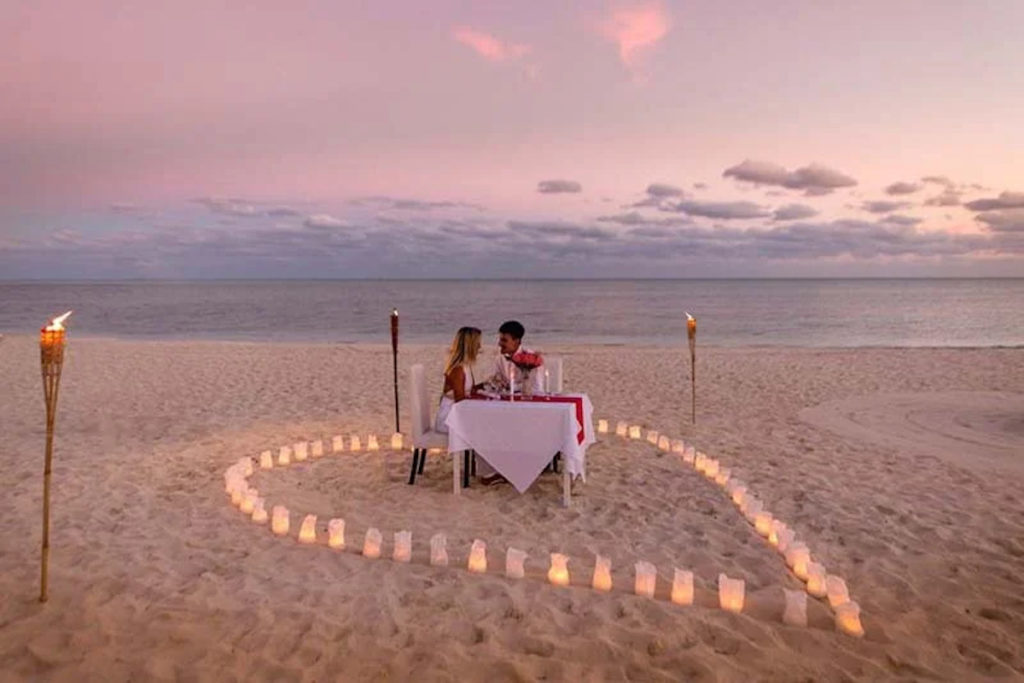 Couple dining on a quiet beach in a romantic setting. Photo c. Viva Wyndham