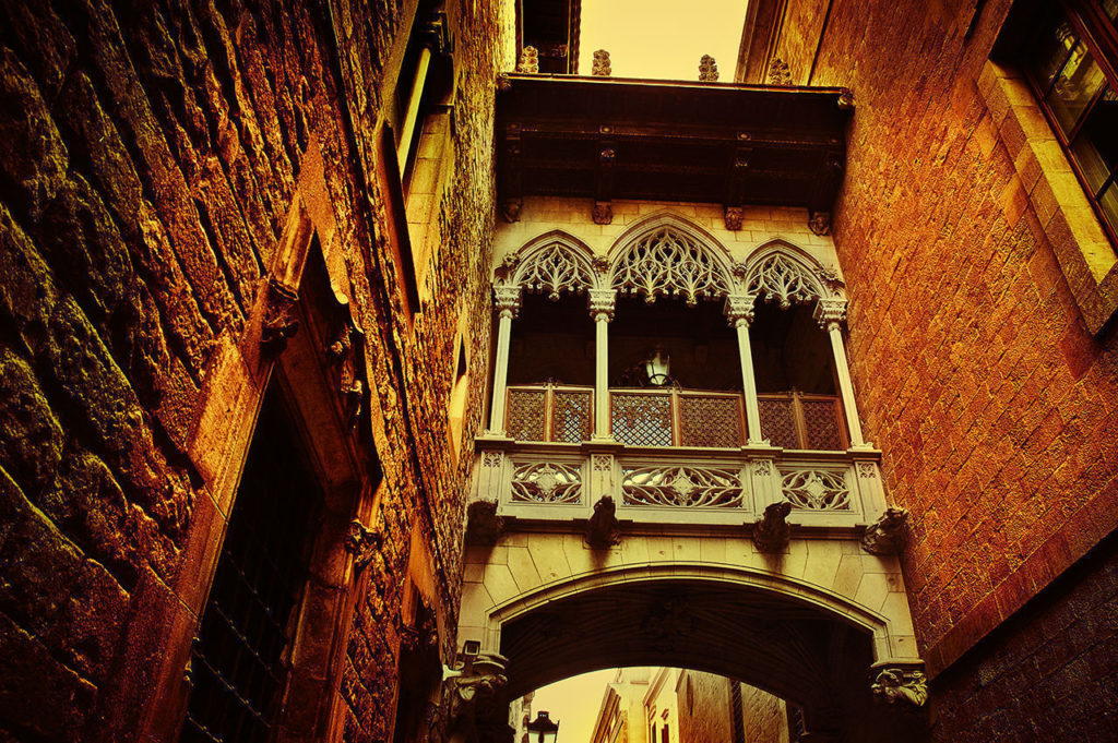An ornate Moorish balcony between two buildings is typical of the architecture in the Old Town of Barcelona.