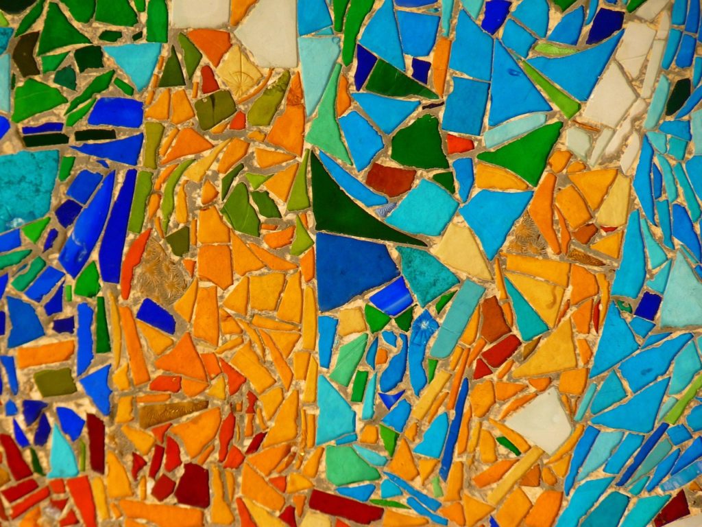 Closeup of a brightly colored mosaic tile wall by Antoni Gaudi seen in Parc Guell, Barcelona's top family atrraction. Photo c. Logga Wiggler for pixabay.