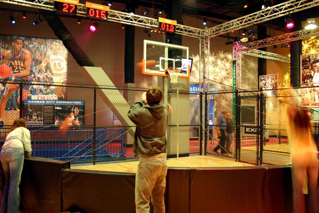Kids shoot hoops at a game basketball net at the College Basketball Experience in Kansas City, MO